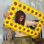 kobieta z ramką z papierowych kwiatów