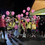 dzieci w żółtych kamizelkach i z różowymi balonami, obok nich stoi wicestarosta