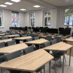 sprzęt komputerowy i biurka w pracowni informatycznej