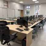 sprzęt komputerowy i biurka w pracowni informatycznej