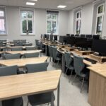 sprzęt komputerowy i biurka w pracowni informatycznej