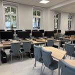 sprzęt komputerowy i biurka w pracowni informatycznej