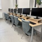 sprzęt komputerowy i biurka w pracowni informatycznej