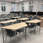 sprzęt komputerowy i biurka w pracowni informatycznej