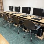 sprzęt komputerowy i biurka w pracowni informatycznej
