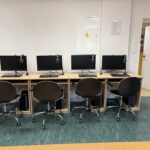 sprzęt komputerowy i biurka w pracowni informatycznej