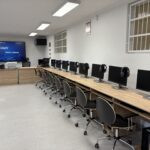 sprzęt komputerowy i biurka w pracowni informatycznej