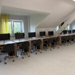 sprzęt komputerowy i biurka w pracowni informatycznej