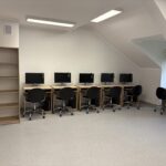 sprzęt komputerowy i biurka w pracowni informatycznej