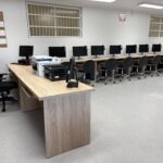 sprzęt komputerowy i biurka w pracowni informatycznej