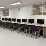 sprzęt komputerowy i biurka w pracowni informatycznej