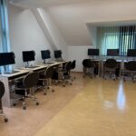 sprzęt komputerowy i biurka w pracowni informatycznej