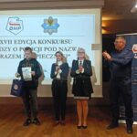 nagrodzony młody chłopak, obok sekretarz, komendant hufca i policjant