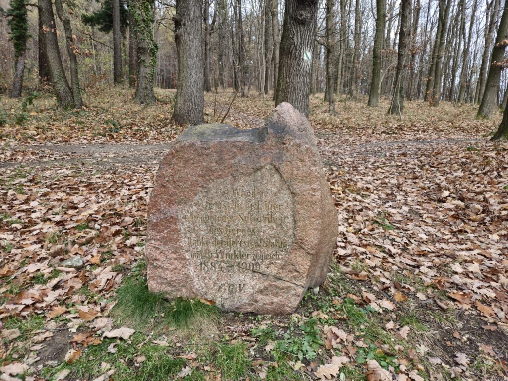 głaz z napisem, w tle drzewa