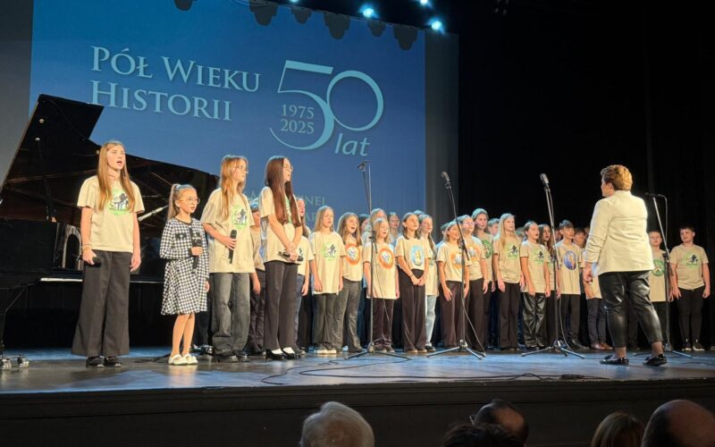 dzieci i młodzież na scenie w dużej grupie śpiewają