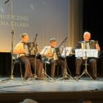 trzy osoby grają na akordeonach