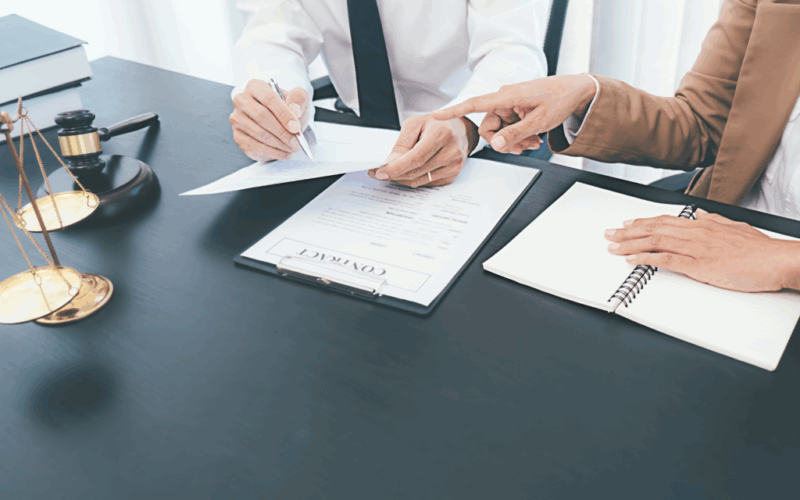 dokumenty i dłonie nad stołem, waga sędziowska