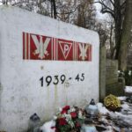 środkowa tablica pomnika, poniżej znicze