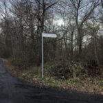 drogowskaz z drogi głównej kierujący do miejsca, gdzie jest pomnik