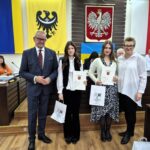 starosta Grzegorz Kosowski, członek zarządu Bernadetta Szczypka i uczniowie z listami gratulacyjnymi 2