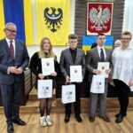 starosta Grzegorz Kosowski, członek zarządu Bernadetta Szczypka i uczniowie z listami gratulacyjnymi 4