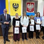 starosta Grzegorz Kosowski, członek zarządu Bernadetta Szczypka i uczniowie z listami gratulacyjnymi 1