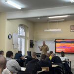 uczniowie podczas szkolenia, przedstawiciel straży pożarnej prowadzi szkolenie przy tablicy