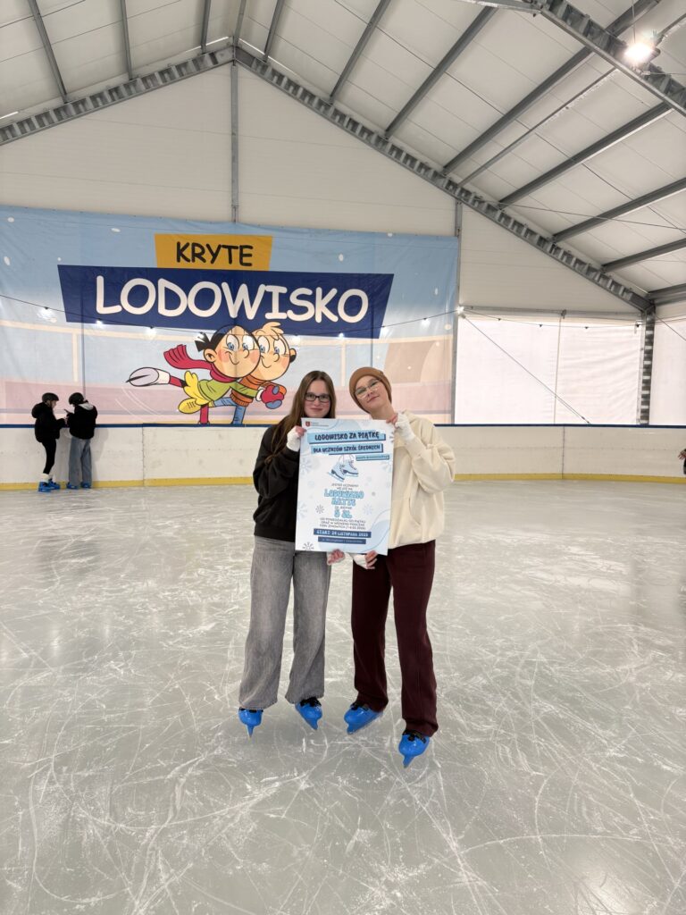 uczennice z plakatem promującym lodowisko