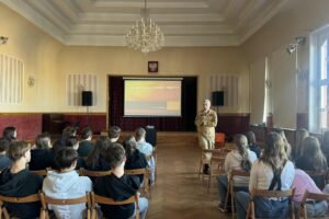 uczniowie podczas szkolenia, przedstawiciel straży pożarnej prowadzi szkolenie przy tablicy