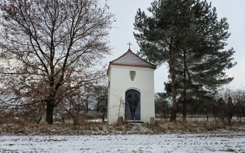 kapliczka widok od frontu w lekkim oddaleniu, wokół drzewa
