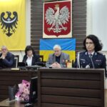 komendant przemawia z mównicy, w tle prezydium