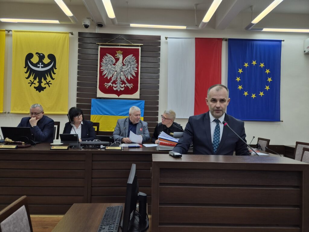 wicestarosta przemawia z mównicy, w tle prezydium rady