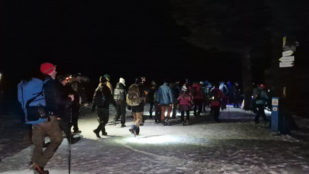 grupa ludzi idący po śniegu widok z tyłu