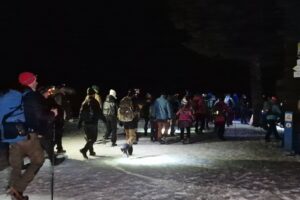 grupa ludzi idący po śniegu widok z tyłu