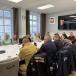 zbliżenie, uczestnicy siedzą przy stole 1