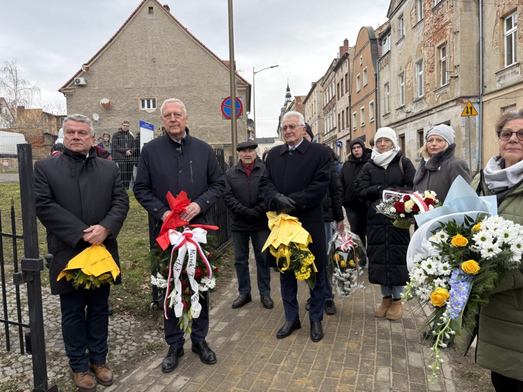 zbliżenie na władze samorządów powiatu z kwiatami podczas uroczystości
