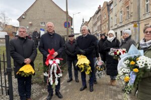 zbliżenie na władze samorządów powiatu z kwiatami podczas uroczystości