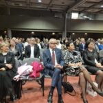 zaproszeni goście siedzą na krzesłach na sali w DOK