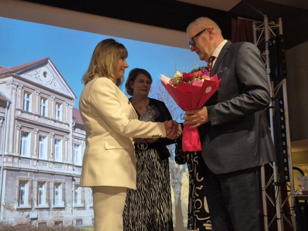 starosta wręcza kwiaty dla dyrektor poradni, w tle radna powiatowa