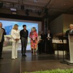 grupowe zdjęcie dyrektorów na scenie jak wręczają prezenty