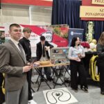 uczniowie przy stoisku promocyjnym