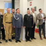 grupowe zdjęcie samorządowców z komendantem straży i dyrektorem aresztu