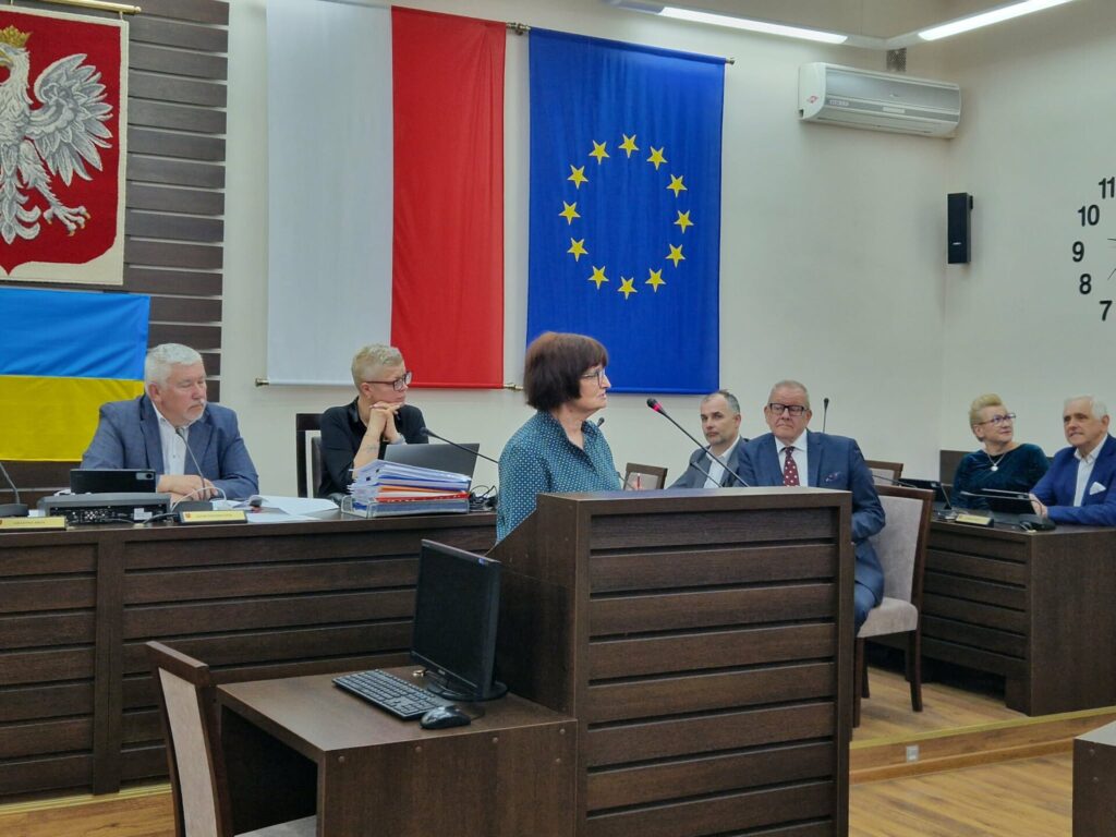 Kierownik Wojewódzkiego Inspektoratu Ochrony Roślin i Nasiennictwa przemawia, w tle prezydium rady