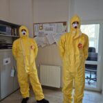 pracownicy sanepidu w żółtych kombinezonach