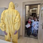 pracownicy sanepidu w żółtym kombinezonie czeka na dzieci