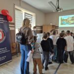 grupa dzieci tyłem, na ekranie wyświetlone 2 zdjęcia