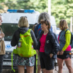 grupa ludzi, w tle stojący ambulans