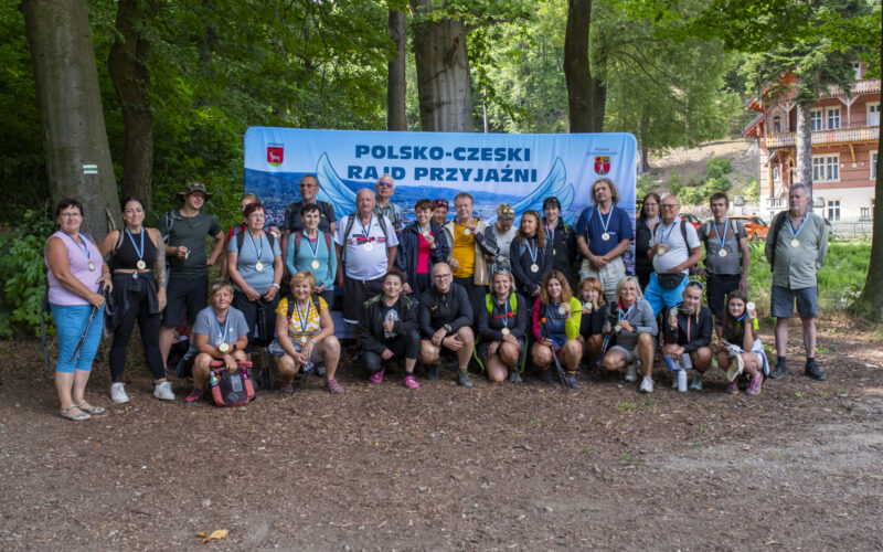 wszyscy uczestnicy rajdu na wspólnym zdjęciu na tle ścianki rajdu