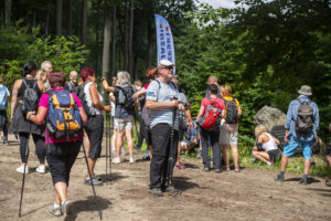 ludzie w turystycznych strojach, za nimi flaga polsko-czeski rajd przyjaźni