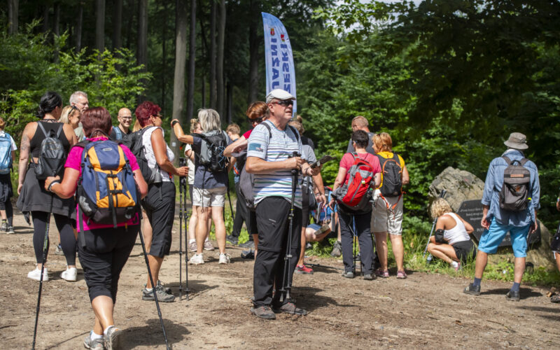 ludzie w turystycznych strojach, za nimi flaga polsko-czeski rajd przyjaźni